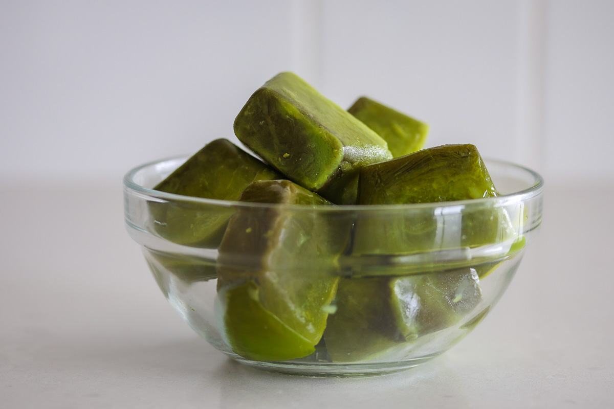 Matcha ice cubes in a glass bowl.