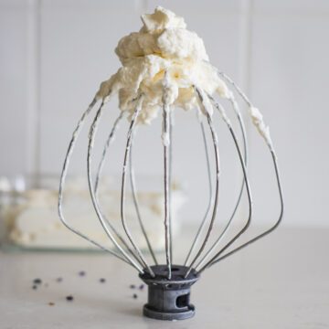 A whisk with lavender whipped cream.