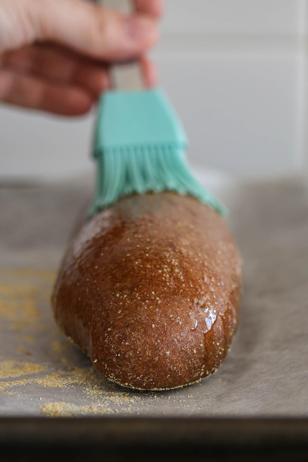 Brushing melted butter on brown bread.