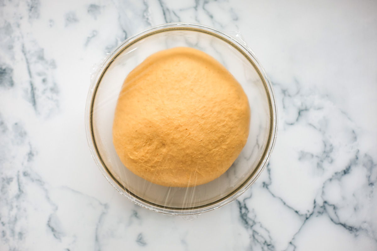 Puffy dough inside glass bowl.