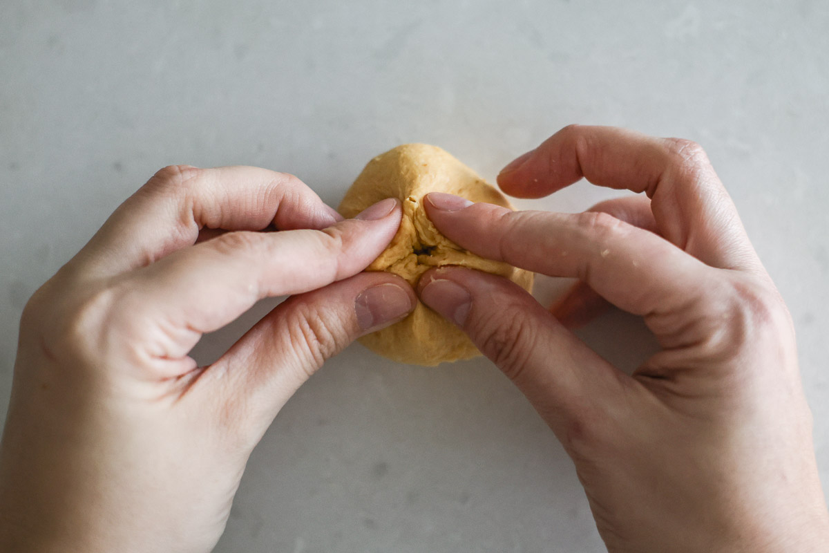 Hand pintching the seams of the dough to close.