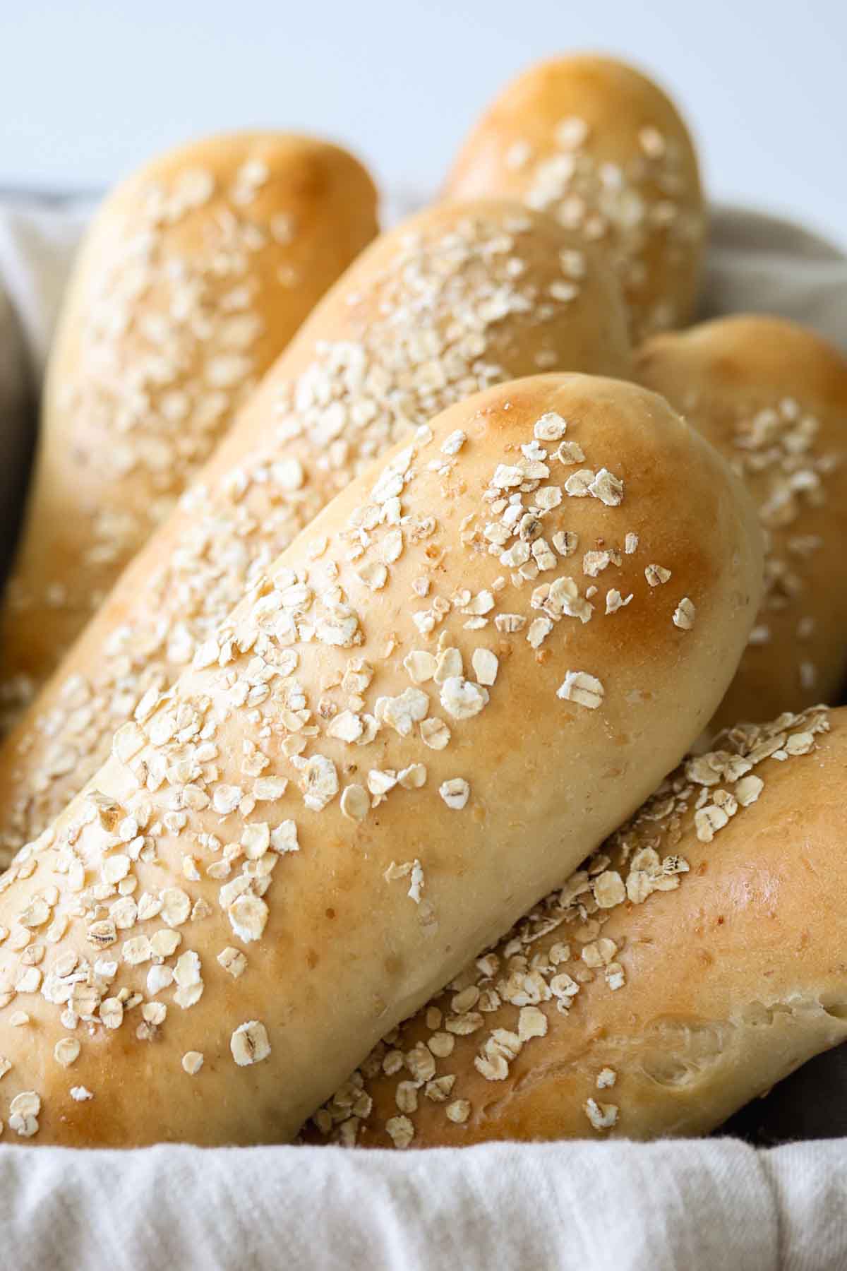 Subway honey oat bread rolls inside a basket.