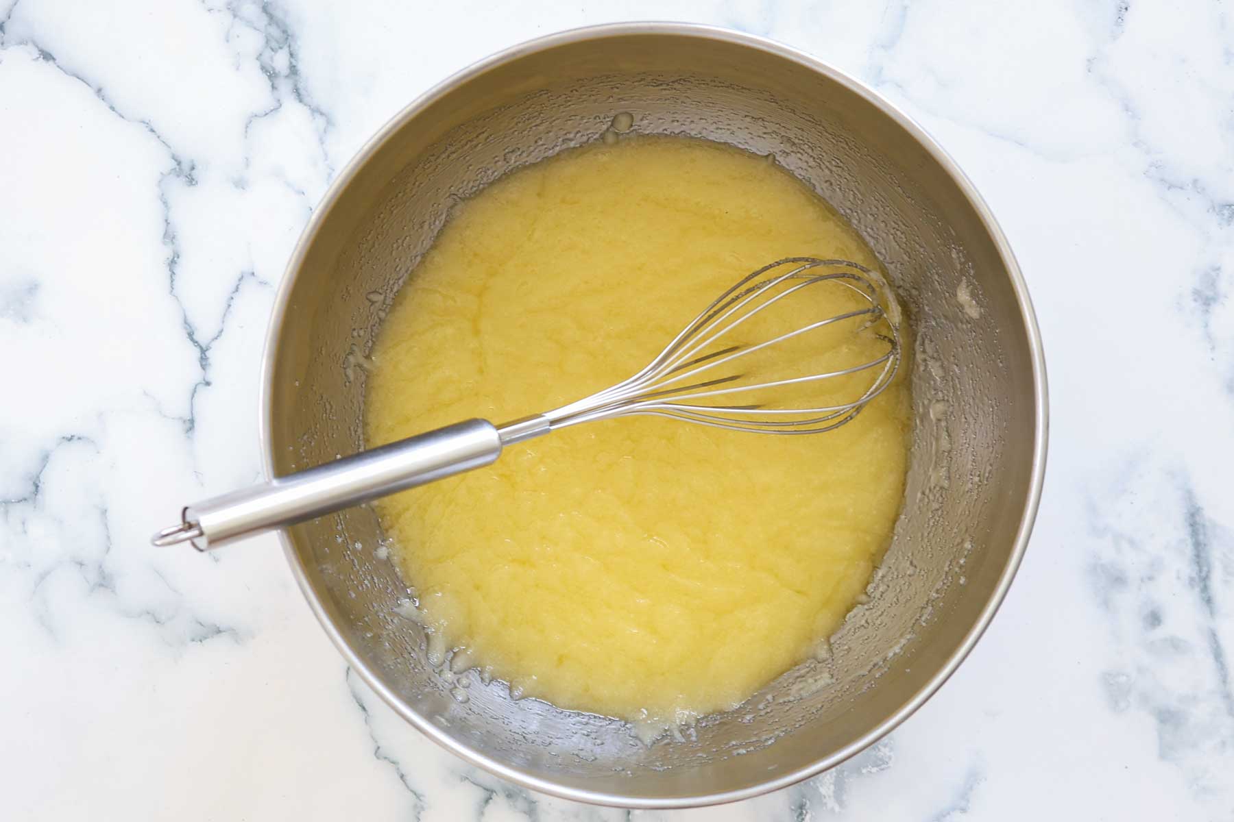 Whisk, butter and sugar whisked, in a metal bowl.