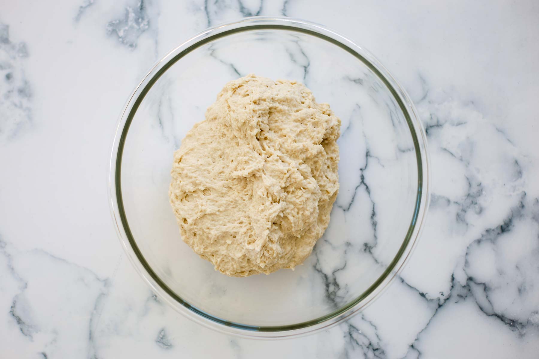 Dough in a glass bowl.