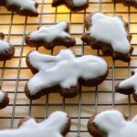 Sourdough gingerbread christmas cookies with icing, over a wire rack.