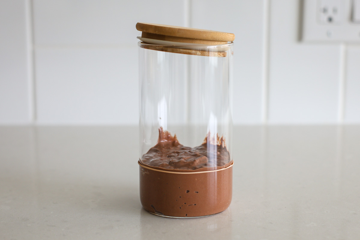 Chocolate sourdough starter after a feeding in a jar, with rubber band.