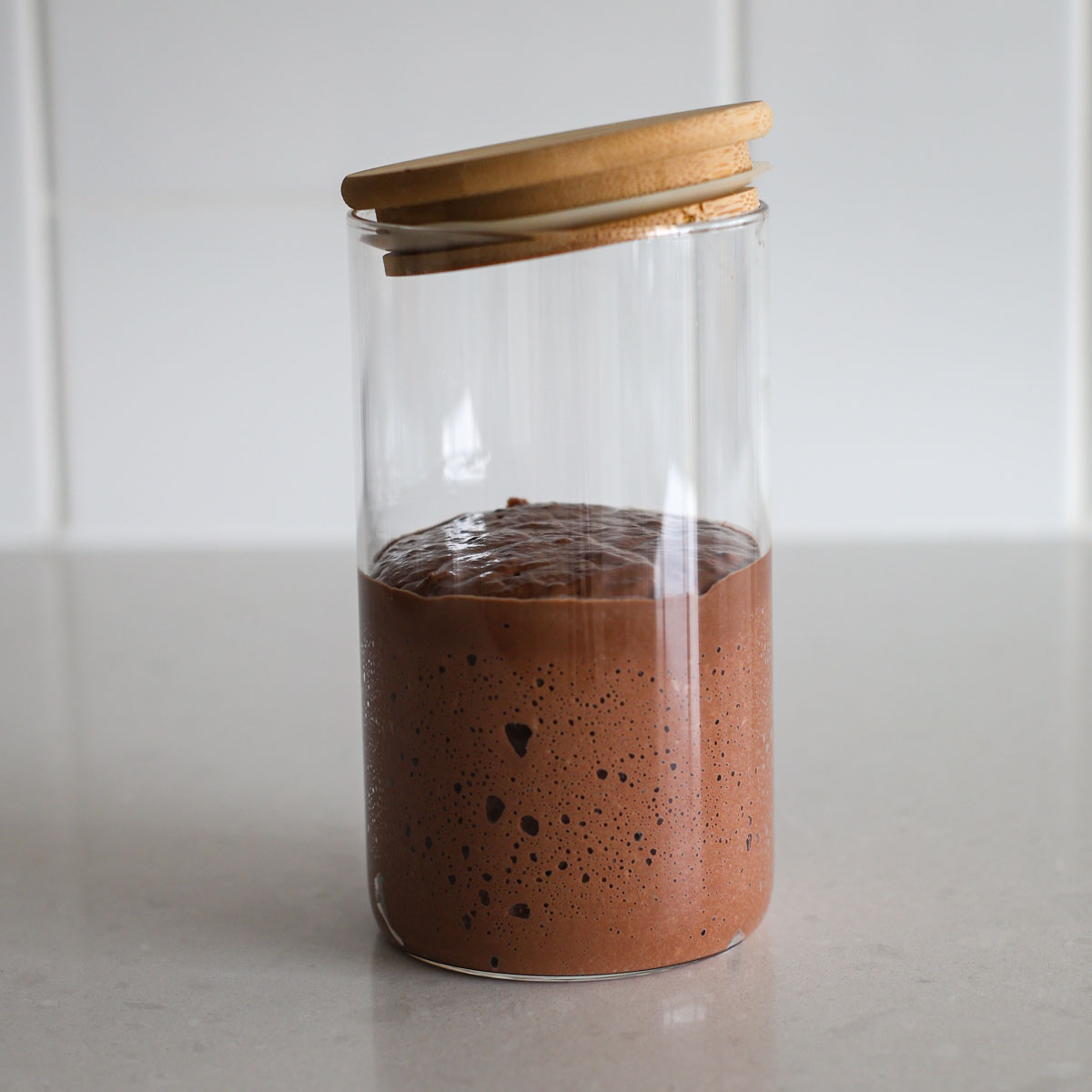 Chocolate sourdough starter in a glass jar.