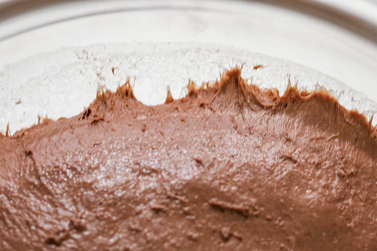 Dough sliding off the tipped glass bowl.