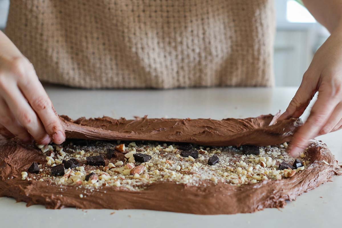 Chocolate dough being folded with add-ins.