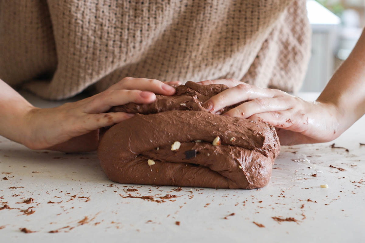 Hand folding chocolate dough.