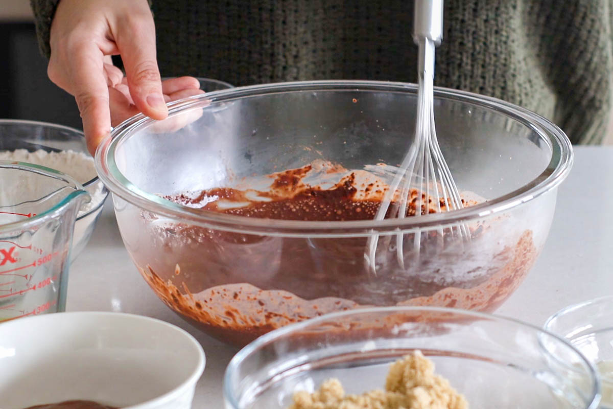 Mixing cocoa with hot milk into a glass bowl.