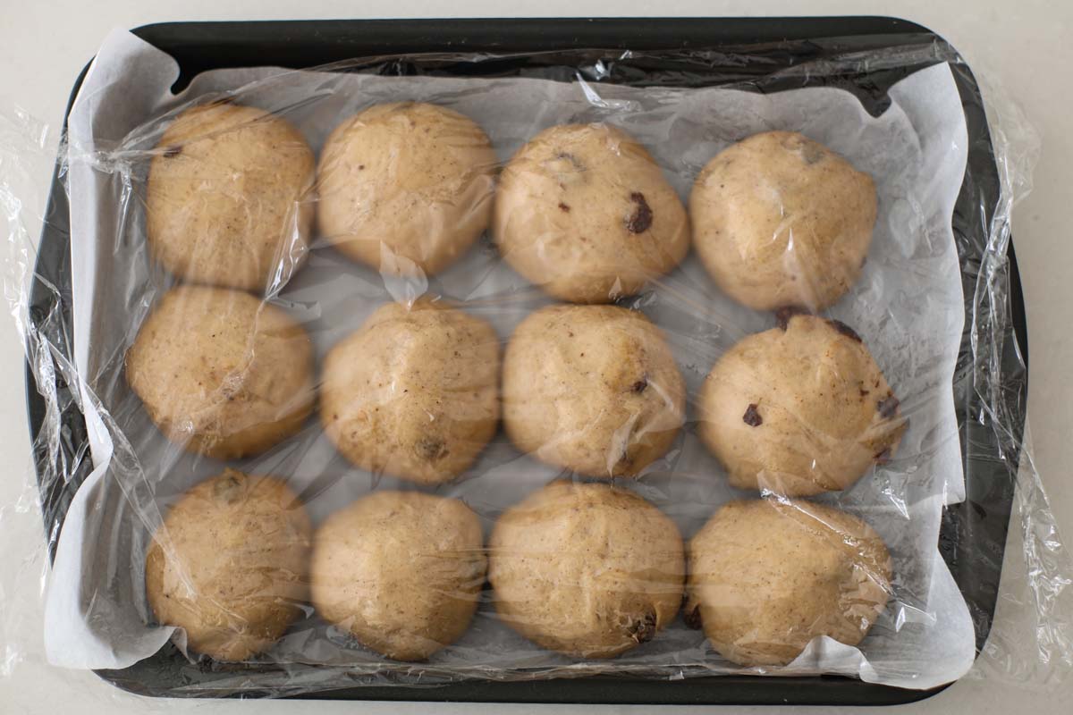 Puffy dough balls inside a baking pan.