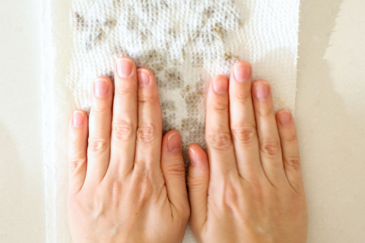 Hands pressin raising on a papel towel.