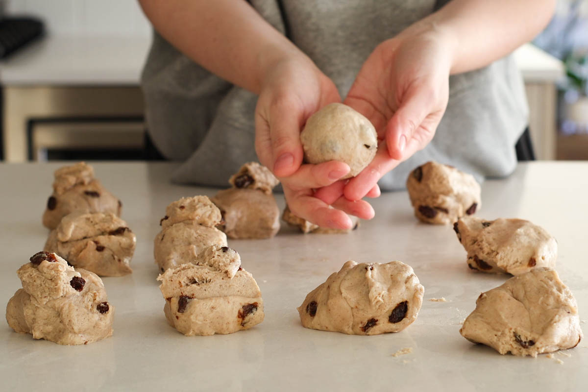 Portioned dough pieces, hand holding a shaped dough ball.