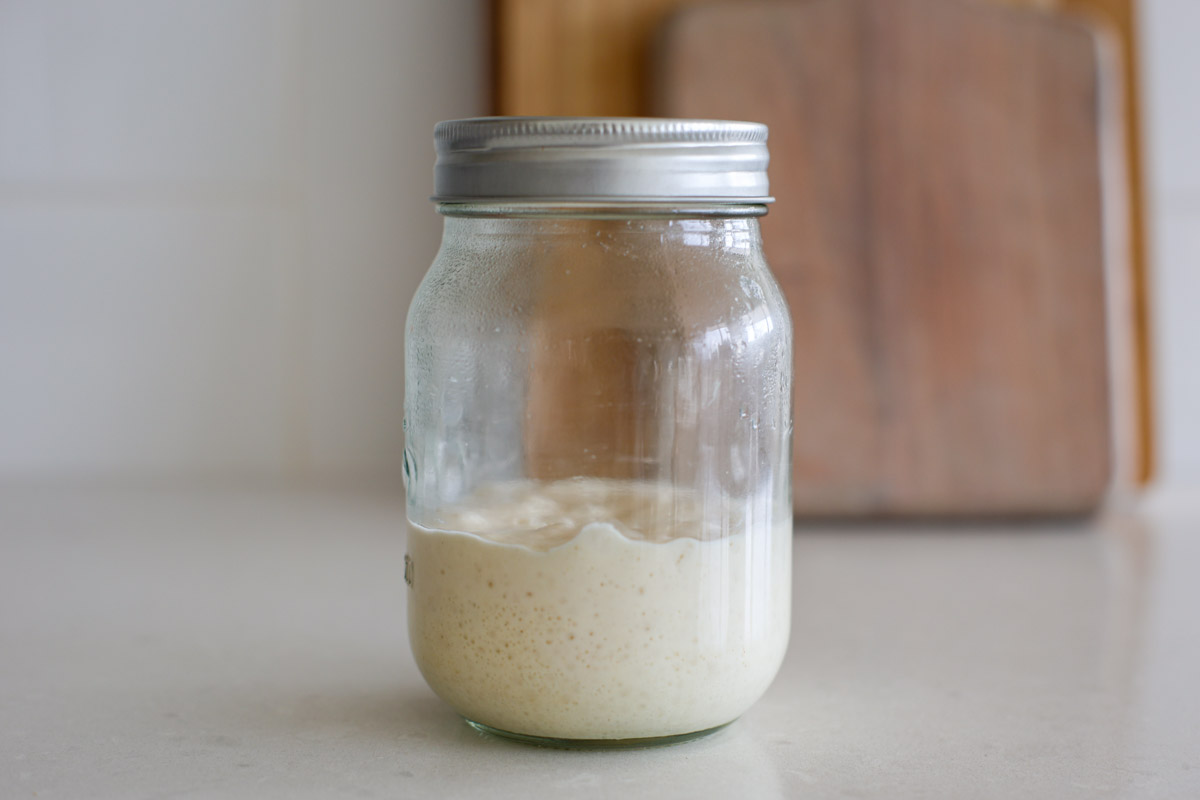 A sourdough starter in a glass jar with bubbles.