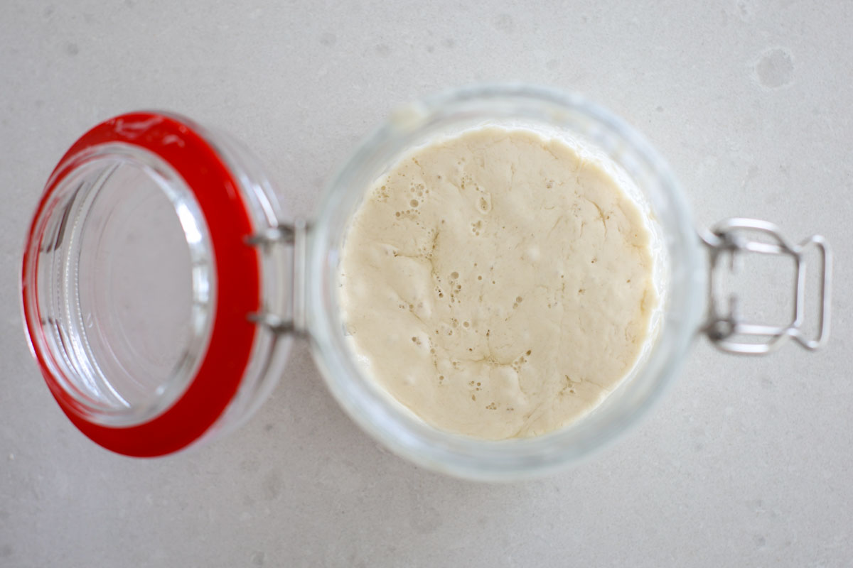 Thin sourdough starter with the begining of a hooch formation.