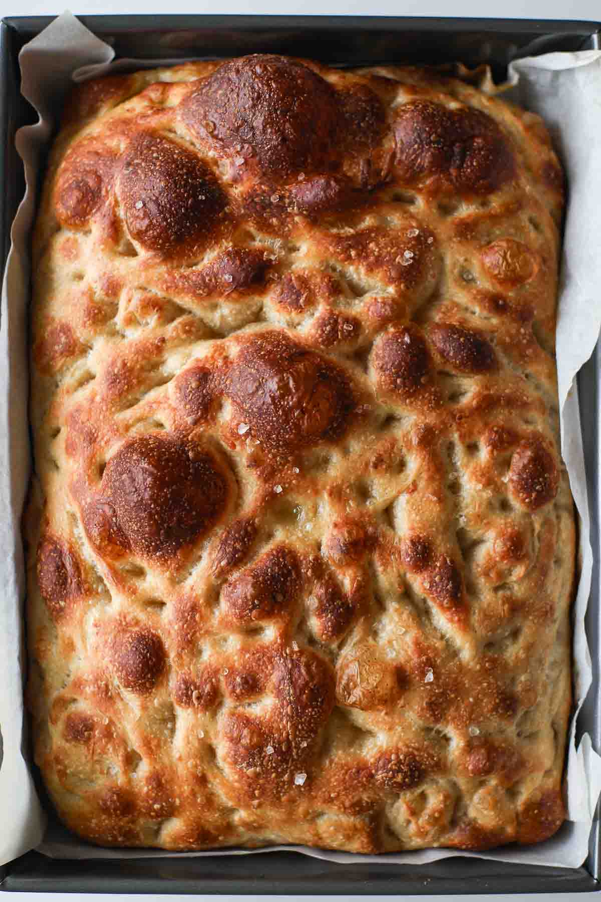 Baked sourdough focaccia with flaky salt on top.